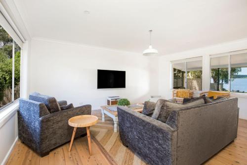 a living room with two couches and a tv at Curleys Outlook I Pet Friendly Waterfront in Culburra Beach