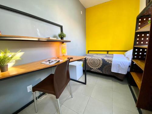a room with a bed and a desk with a desk at ROOMIES HOSTEL Parque México in Mexico City