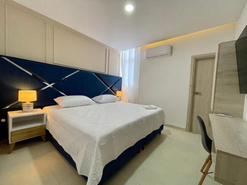 a bedroom with a large bed with a blue headboard at HOTEL PROVINCIA PLAZA in San Juan del Cesar