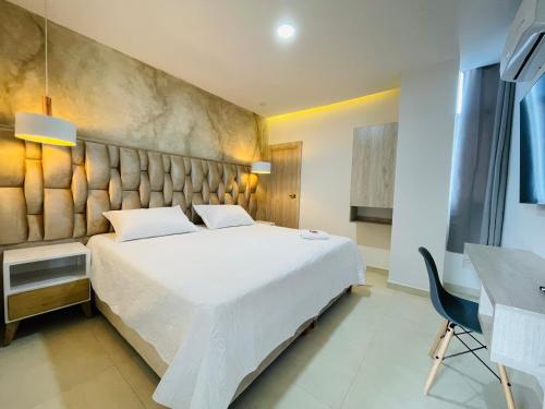 a bedroom with a large white bed and a desk at HOTEL PROVINCIA PLAZA in San Juan del Cesar