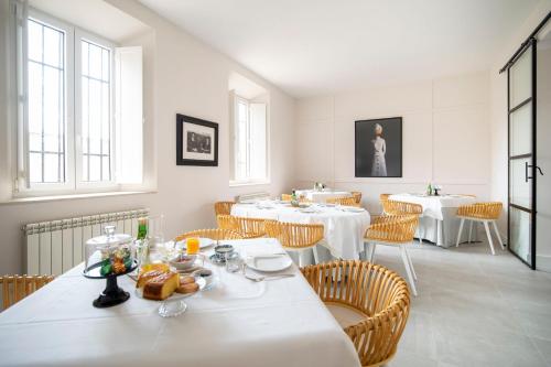 uma sala de jantar com mesas e cadeiras brancas em SANMARTINA HOTEL em Becerril de Campos