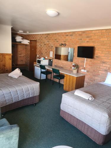 ein Hotelzimmer mit 2 Betten, einer Küche und einem Schreibtisch in der Unterkunft Regency Court Motel in Cobram