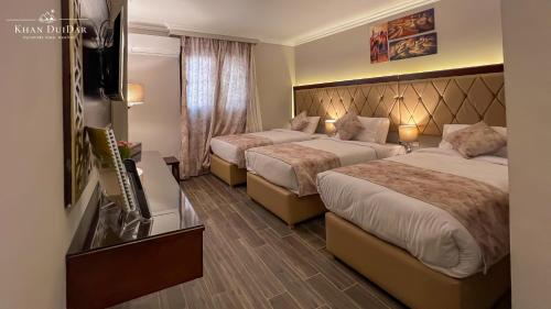 a hotel room with two beds and a television at Khan Duidar Inn - Pyramids View Rooftop in Cairo