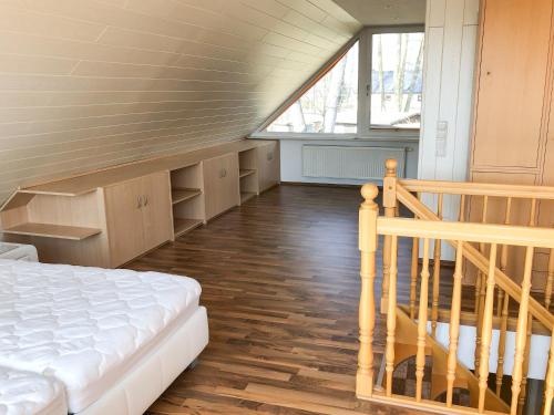 a room with a bed and a staircase with a window at Ferienhaus direkt an der Spree mit Whirlpool und Sauna in Berlin