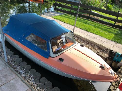 a boat with a blue roof sitting in the water at Ferienhaus direkt an der Spree mit Whirlpool und Sauna in Berlin