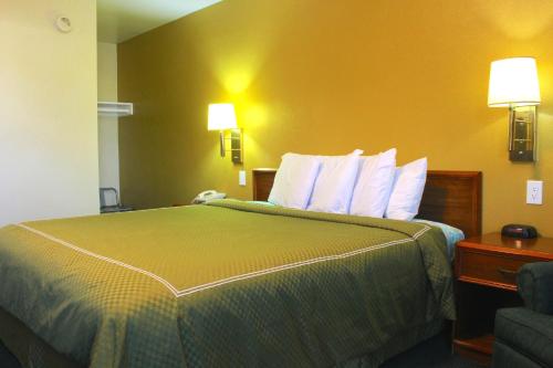 Habitación de hotel con cama grande con almohadas blancas en Echo Lodge, en West Sacramento