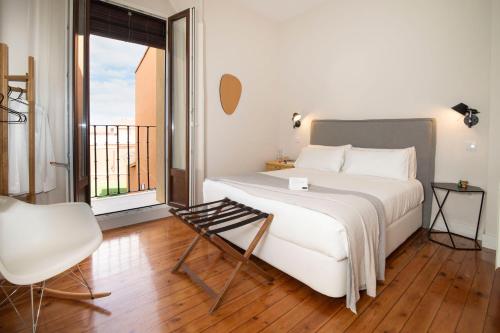 a bedroom with a bed and a chair and a window at SANMARTINA HOTEL in Becerril de Campos