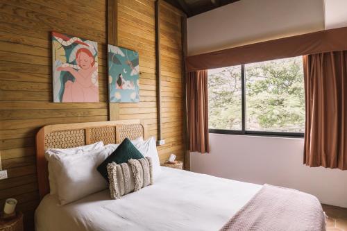 a bedroom with a bed and a window at Selina Poc Na Isla Mujeres in Isla Mujeres