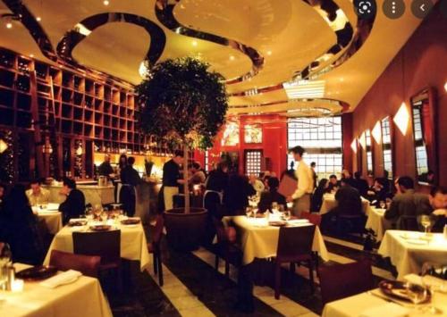 a restaurant with white tables and people sitting at tables at Downtown King Suite-Surround Views-Pool/Gym/Parkng in Vancouver
