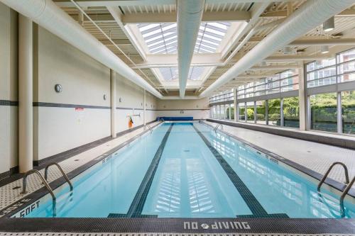 a large indoor swimming pool with a large ceiling at Downtown King Suite-Surround Views-Pool/Gym/Parkng in Vancouver
