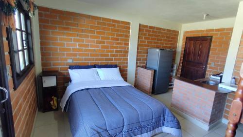 a bedroom with a bed and a brick wall at Kantinho do Mar in São Francisco do Sul