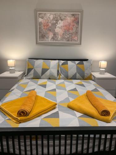 Fantastic 1 Bedroom Basement flat with free parking في سال: سرير وفوط صفراء فوقه