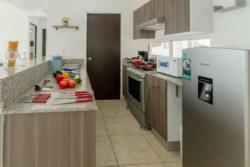 a kitchen with a refrigerator and a counter with vegetables on it at Exclusive building 6 people 3 cable televisions 3 swimming pools balcony, in Cancún