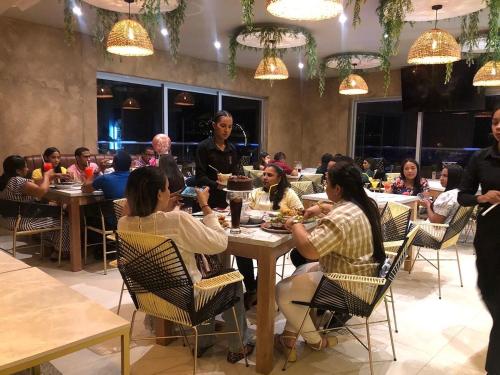 a group of people sitting at tables in a restaurant at HOTEL PROVINCIA PLAZA in San Juan del Cesar