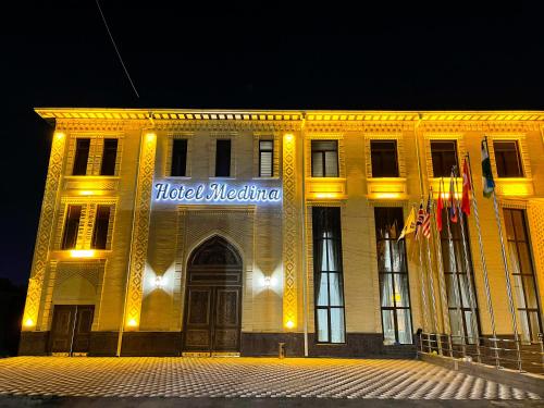 a building with a sign on the front of it at Medina Hotel Samarkand in Samarkand