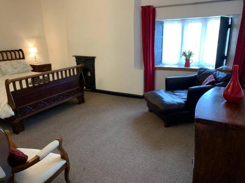 a living room with a couch and a bed and a chair at 6 Bedroom Farm House with 12 Beds in Weldon in Weldon