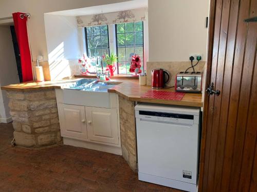 a kitchen with a counter with a sink and a dishwasher at 6 Bedroom Farm House with 12 Beds in Weldon in Weldon