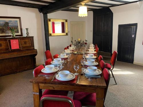 a long table in a room with red chairs at 6 Bedroom Farm House with 12 Beds in Weldon in Weldon