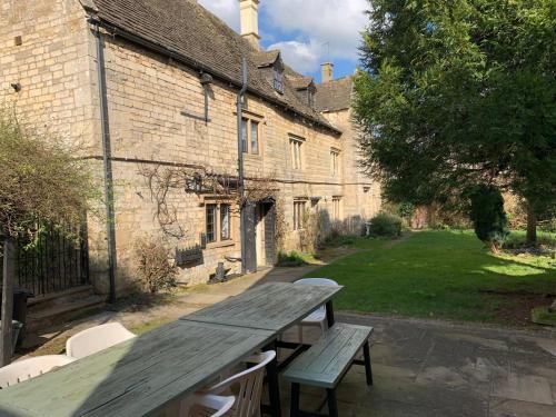 a wooden picnic table in front of a building at 6 Bedroom Farm House with 12 Beds in Weldon in Weldon