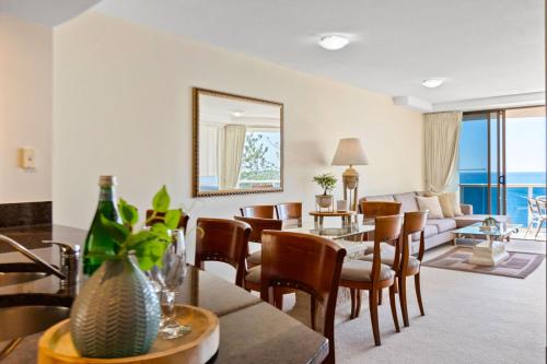 a living room with a table and chairs and a couch at Zanzibar 905, Ocean front 2 bedroom apartment in Mooloolaba
