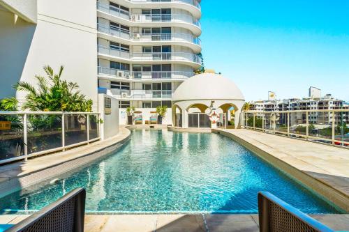 a swimming pool in front of a building at Zanzibar 905, Ocean front 2 bedroom apartment in Mooloolaba
