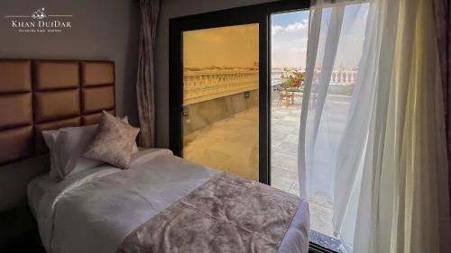 a bedroom with a bed and a view of a balcony at Khan Duidar Inn - Pyramids View Rooftop in Cairo