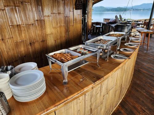 a buffet on a boat with plates and food at บ้านไร่ วรรณ วาลย์ รีสอร์ท in Tha Kradan