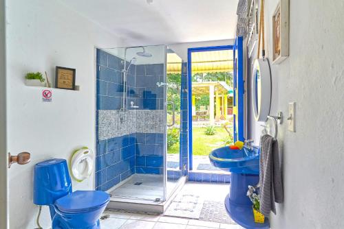 a blue bathroom with a shower and a toilet at Villa con Piscina-BBQ-Gazebo-Fogata-Hamacas in Básima