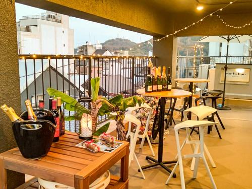 een tafel en stoelen op een balkon met uitzicht bij Mange Tak Resort Onomichi in Onomichi