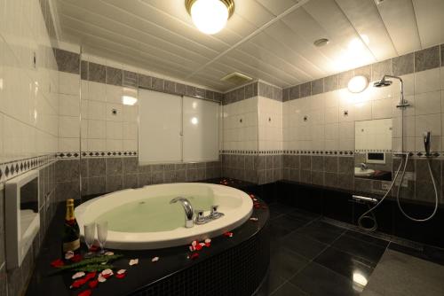 a bathroom with a sink and a bath tub at Hotel S-CUBE (Adult Only) in Bando