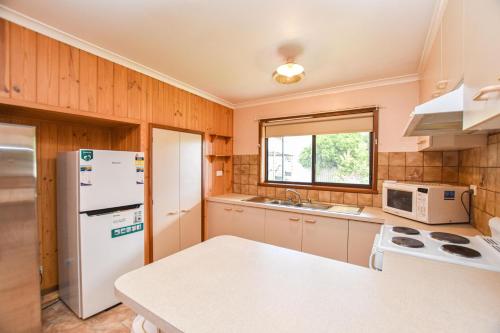 a kitchen with a white refrigerator and a sink at Jamieson Cottage in Myrtleford