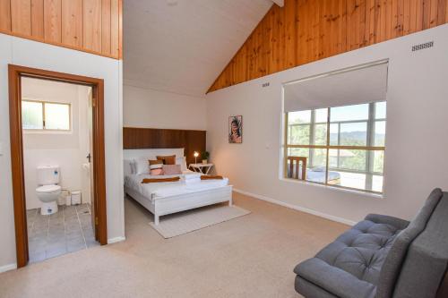 um quarto com uma cama, um sofá e uma janela em Casa Grande em Myrtleford