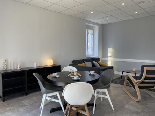 un salon avec une table, des chaises et un canapé dans l'établissement Maison rénovée avec jardin, BBQ, animaux acceptés - FR-1-489-341, à La Chabanne