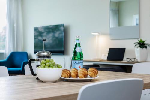 een tafel met een kom druiven en een fles frisdrank bij Quest Mawson Lakes in Adelaide