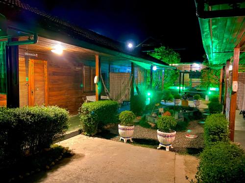 a home at night with green lights in the yard at Pousada Recanto Ninho Verde Chalés in Campos do Jordão