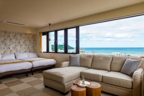 a living room with a couch and a view of the ocean at Blue Steak Wonder Yomitan in Yomitan