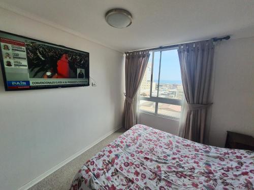 a bedroom with a bed and a large window at Edificio Bulnes Iquique doble in Iquique