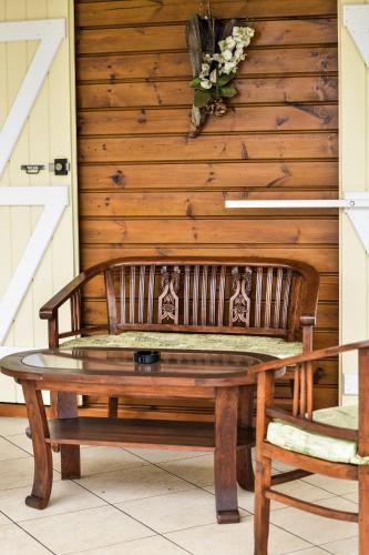 a wooden bench sitting next to a wall with a flower arrangement at ORKY-MEL in Petite Île