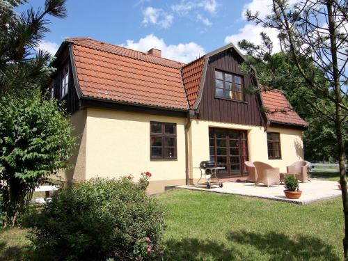 a small white house with a brown roof at Ferienhaus Monika in Wendorf im Bernstein Resort in Wendorf