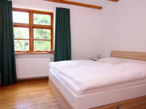 a bedroom with a bed with green curtains and a window at Ferienhaus Monika in Wendorf im Bernstein Resort in Wendorf