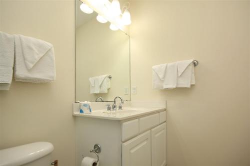 bagno bianco con lavandino e specchio di 2302 Crow Creek Drive a Calabash