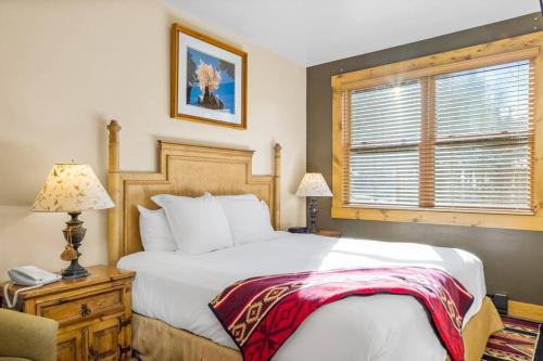 um quarto com uma grande cama branca e uma janela em Blue Collar Boutique: Affordable Adventure em Telluride