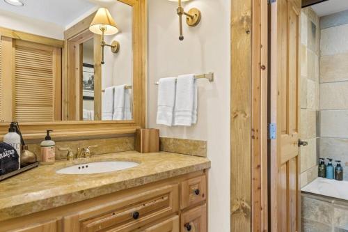 a bathroom with a sink and a mirror and a shower at Blue Collar Boutique: Affordable Adventure in Telluride