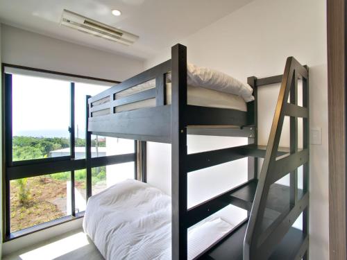 un letto a castello in una stanza con una finestra di ADANRESORT LANA Villa Suite a Motobu