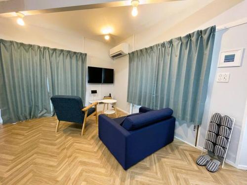 a living room with a blue chair and a table at Tsunore51 in Kashima