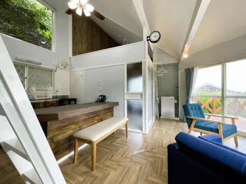 a living room with a couch and a clock on the wall at Tsunore51 in Kashima