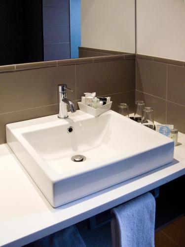a white sink in a bathroom with a mirror at Hotel Sant Roc in Calella de Palafrugell