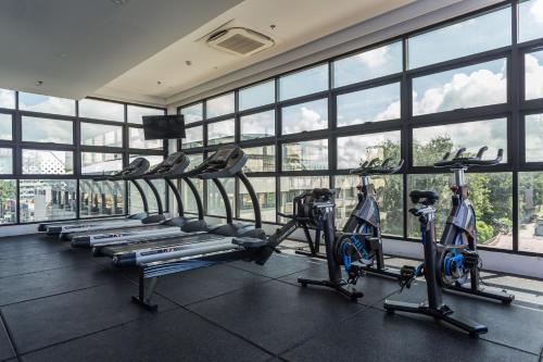 a gym with several tread machines in a room with windows at Stonehill Suites in Bacolod