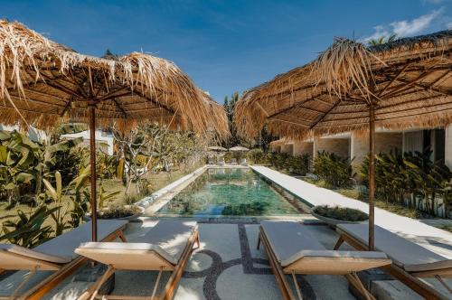 ein Resort mit einem Pool mit Stühlen und Sonnenschirmen in der Unterkunft Origin Lombok in Kuta Lombok