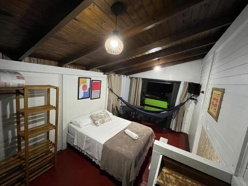 a small room with a bed in a house at Chalês Santa Marta in Farol de Santa Marta
